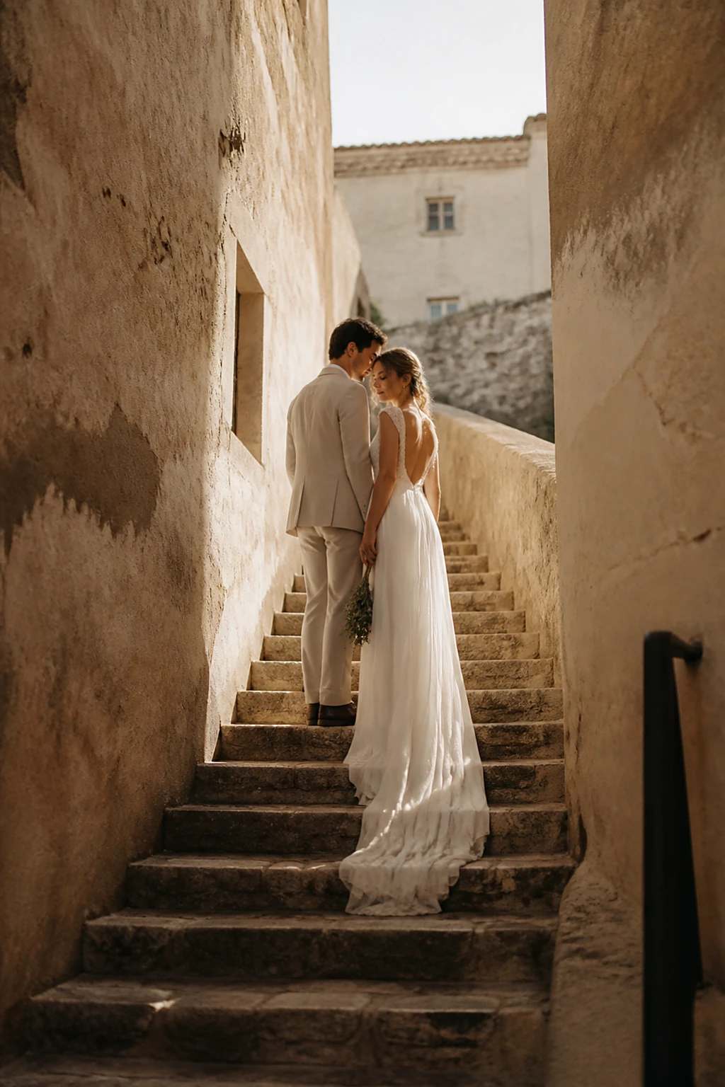 A couple pausing on an ancient stone stairway in a hilltop village
