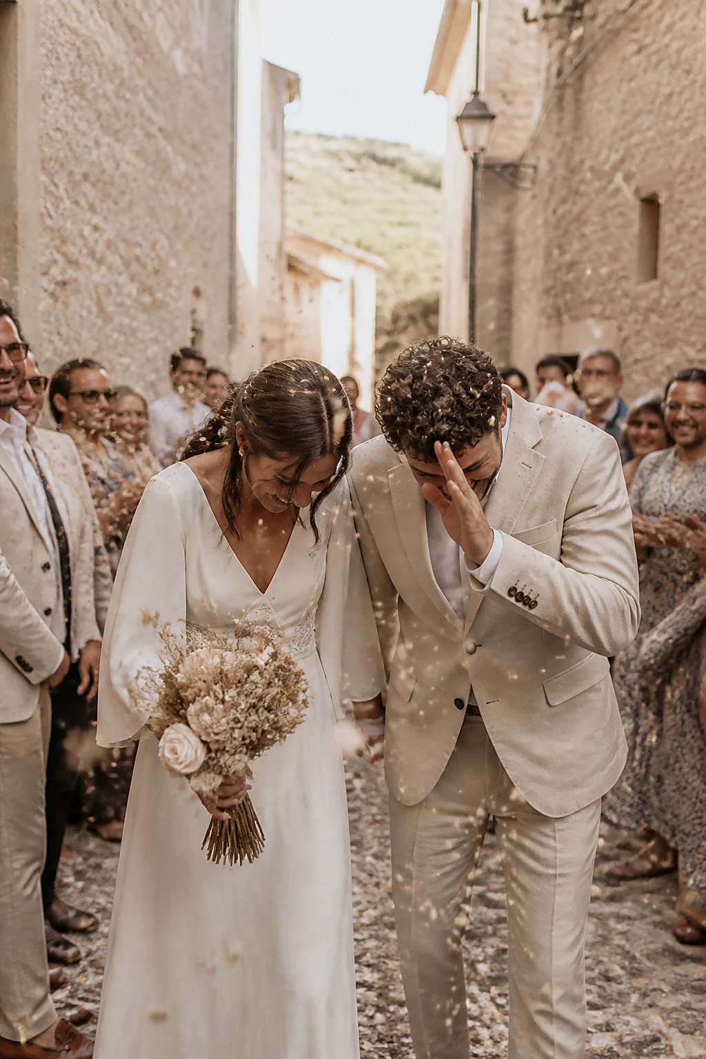 A joyful confetti exit down a narrow village path